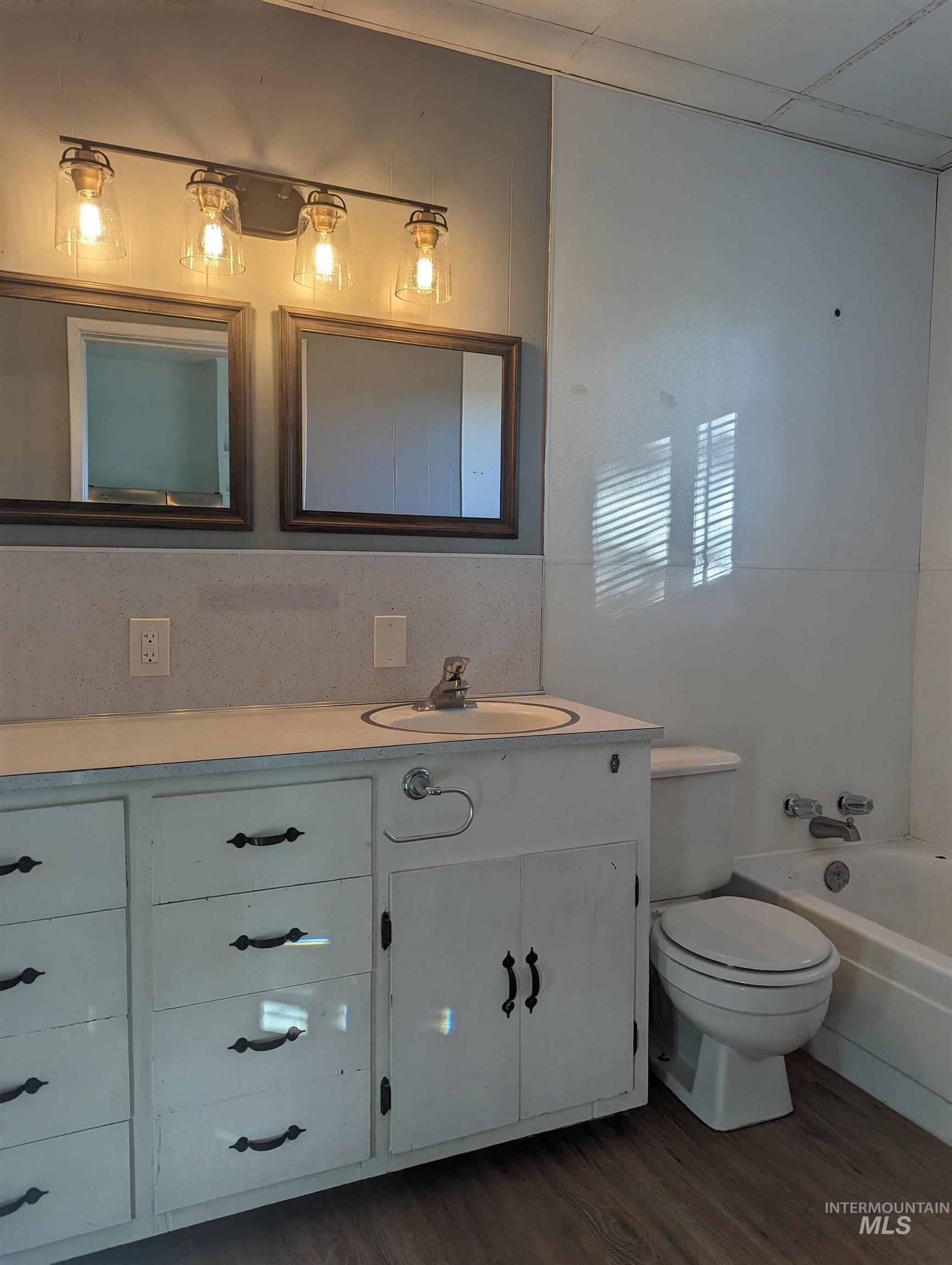 Full bath with vanity, dark wood finished floors, and bathtub / shower combination