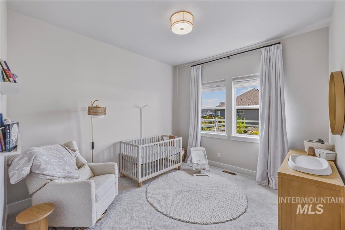 Bright interior space featuring light-toned walls, a round ceiling fixture, and twin windows with white trim