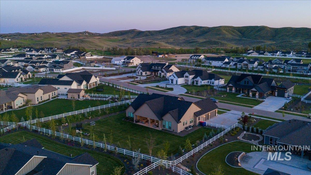 Expansive neighborhood setting featuring diverse residential architecture, green landscaping, paved streets, and a backdrop of rolling hills