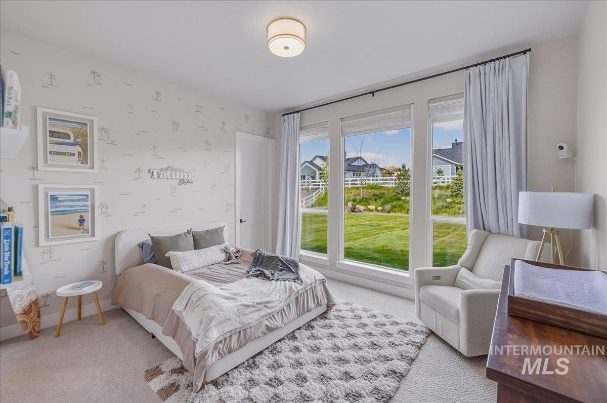 Floor-to-ceiling windows featuring a landscape of green space and distant homes