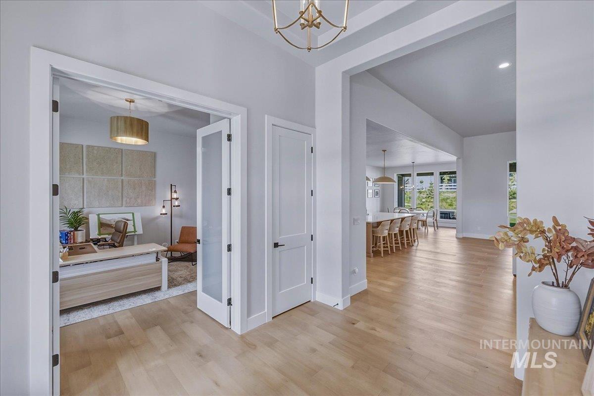 Light wood-finish flooring throughout, with a dedicated room featuring double French doors with frosted panels