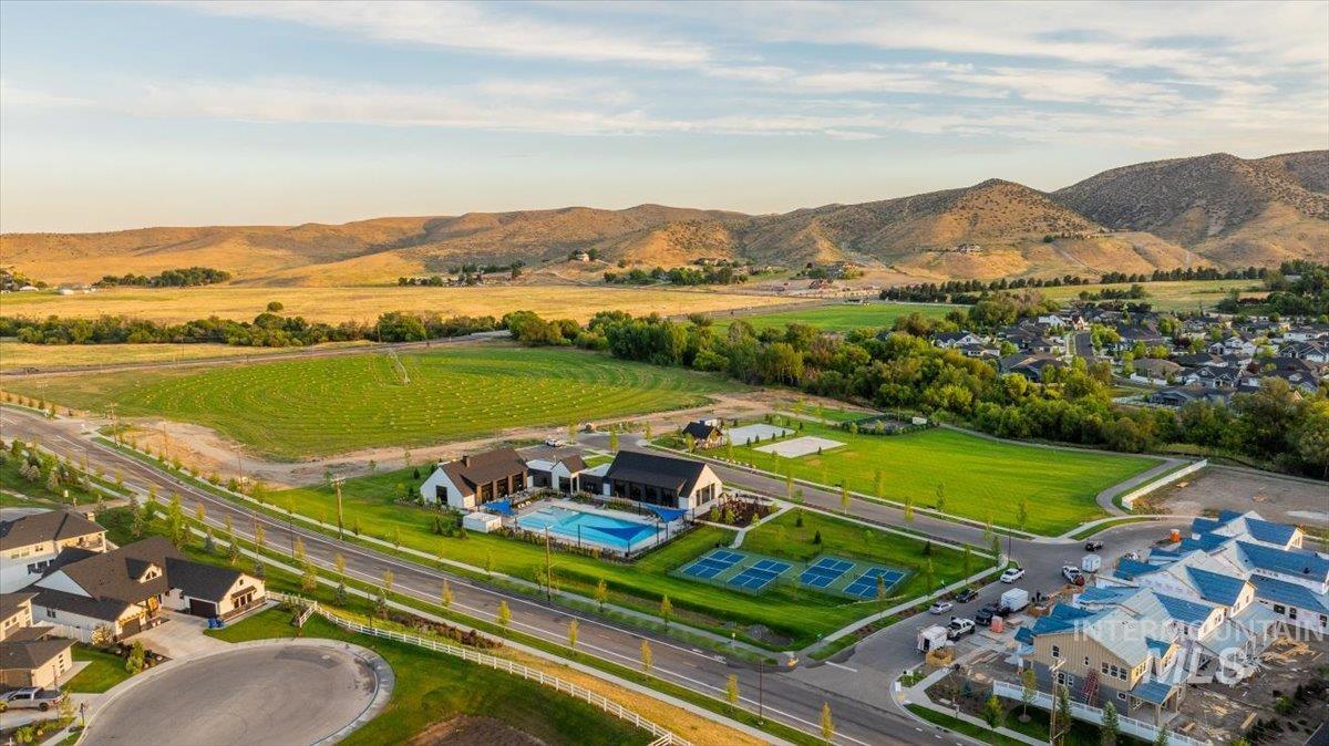 Expansive community amenities featuring a large outdoor swimming pool, four multi-sport courts, and a manicured green space