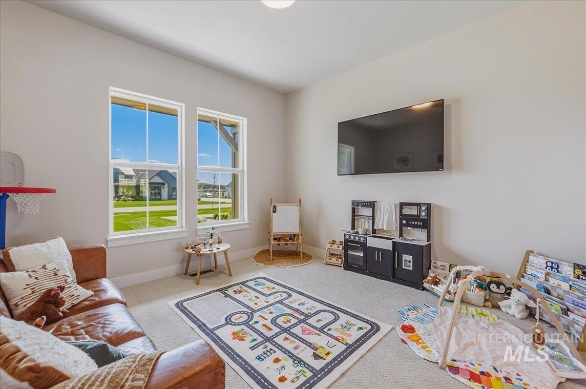 Bright room featuring two large windows, light-colored walls, and carpeting