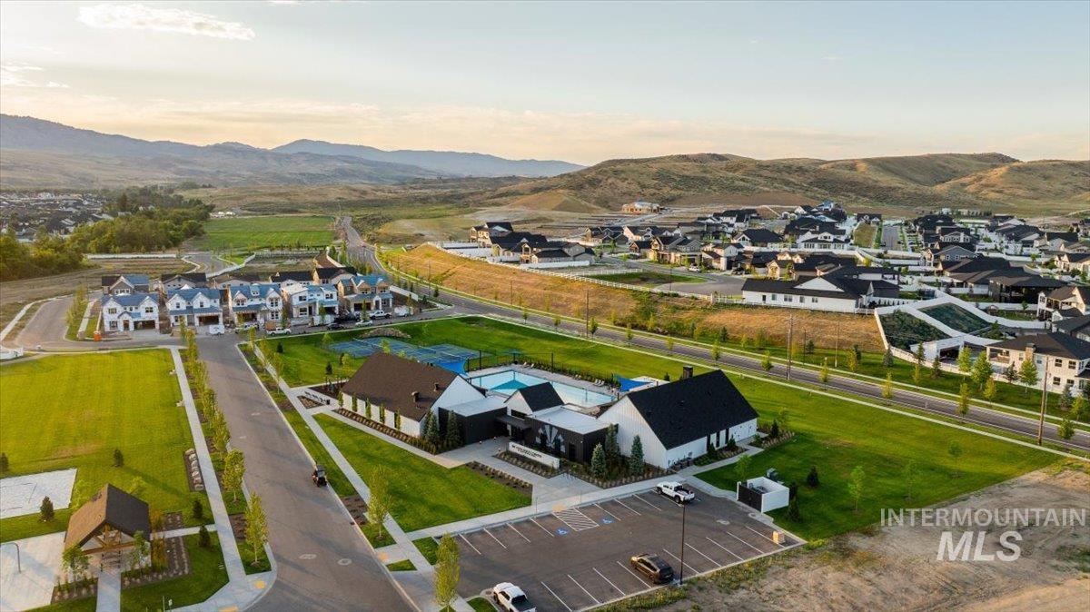Community clubhouse with a swimming pool, tennis courts, and expansive green spaces