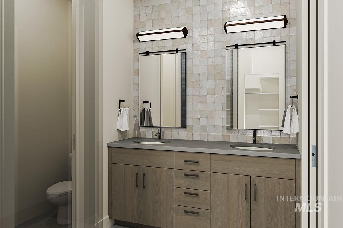 Bathroom featuring double vanity and toilet