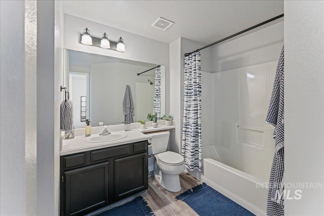 Bathroom featuring vanity, wood finished floors, and shower / tub combo