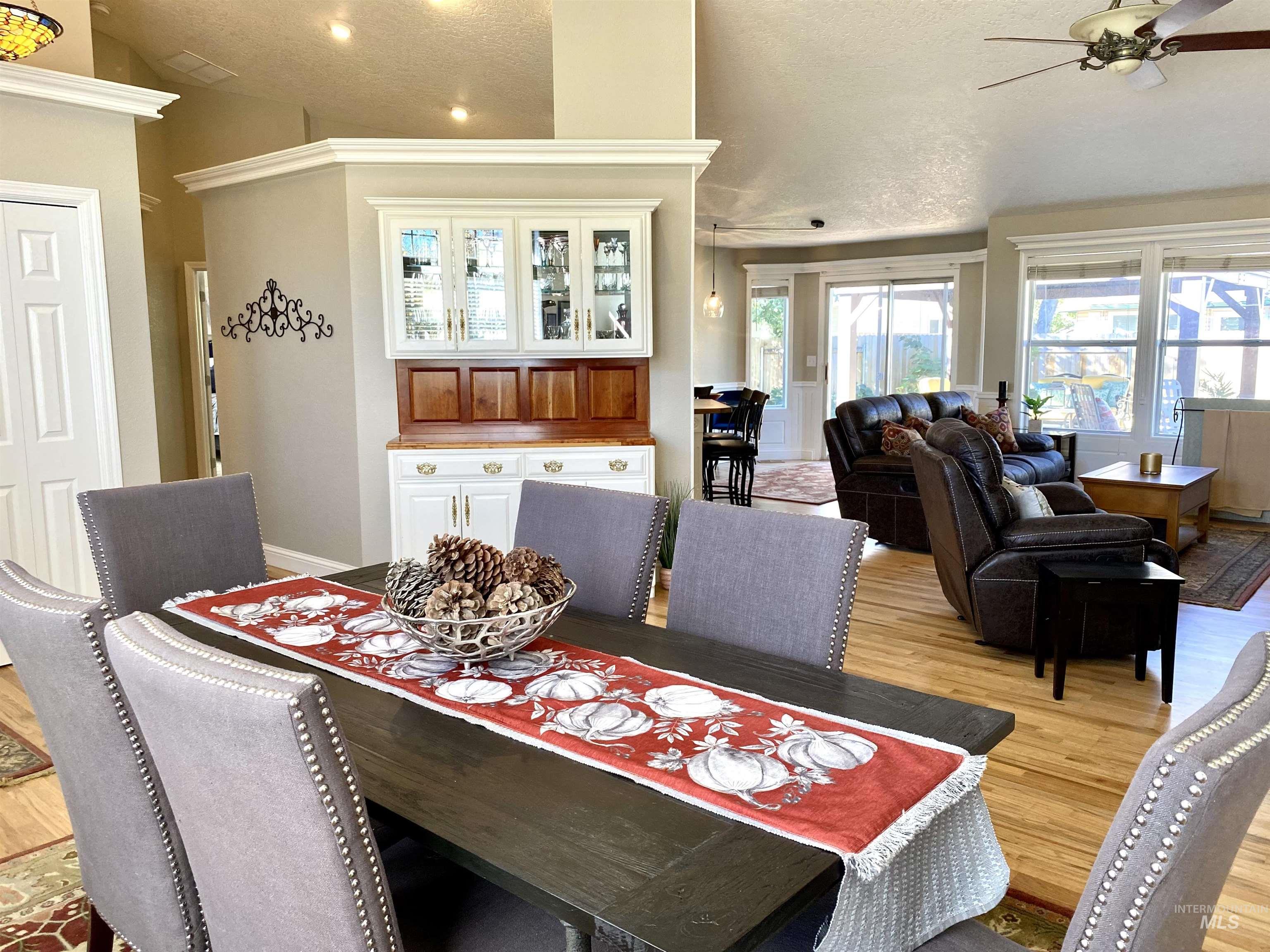 Dining area with light wood-style flooring, a textured ceiling, healthy amount of natural light, a ceiling fan, and recessed lighting