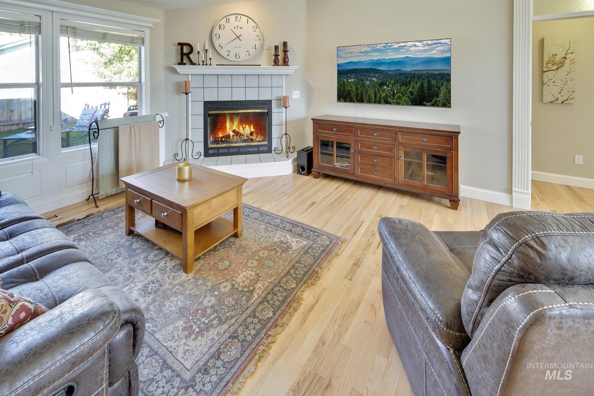 Living room featuring light wood-style flooring and a fireplace