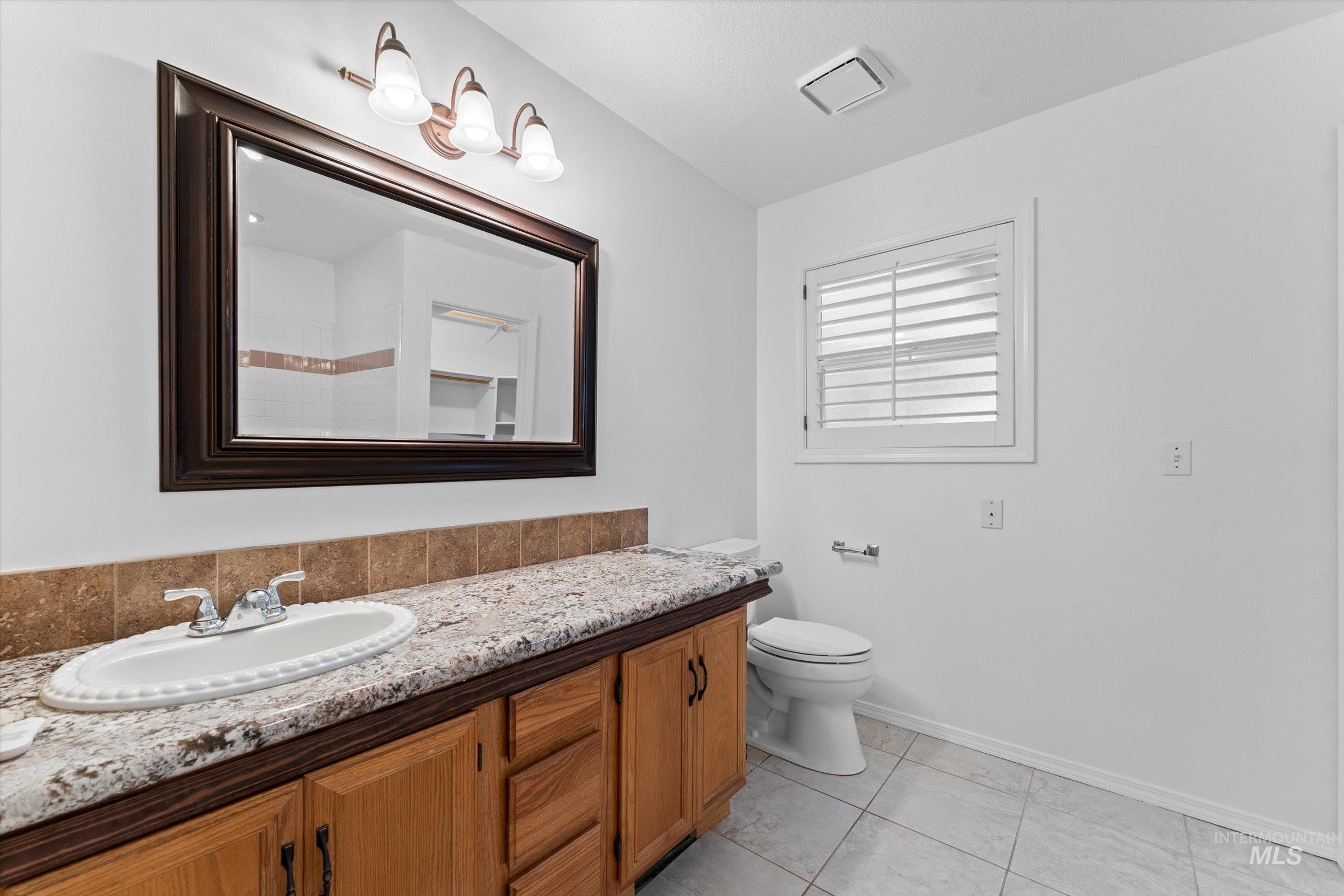 Full bathroom with vanity and light tile patterned floors