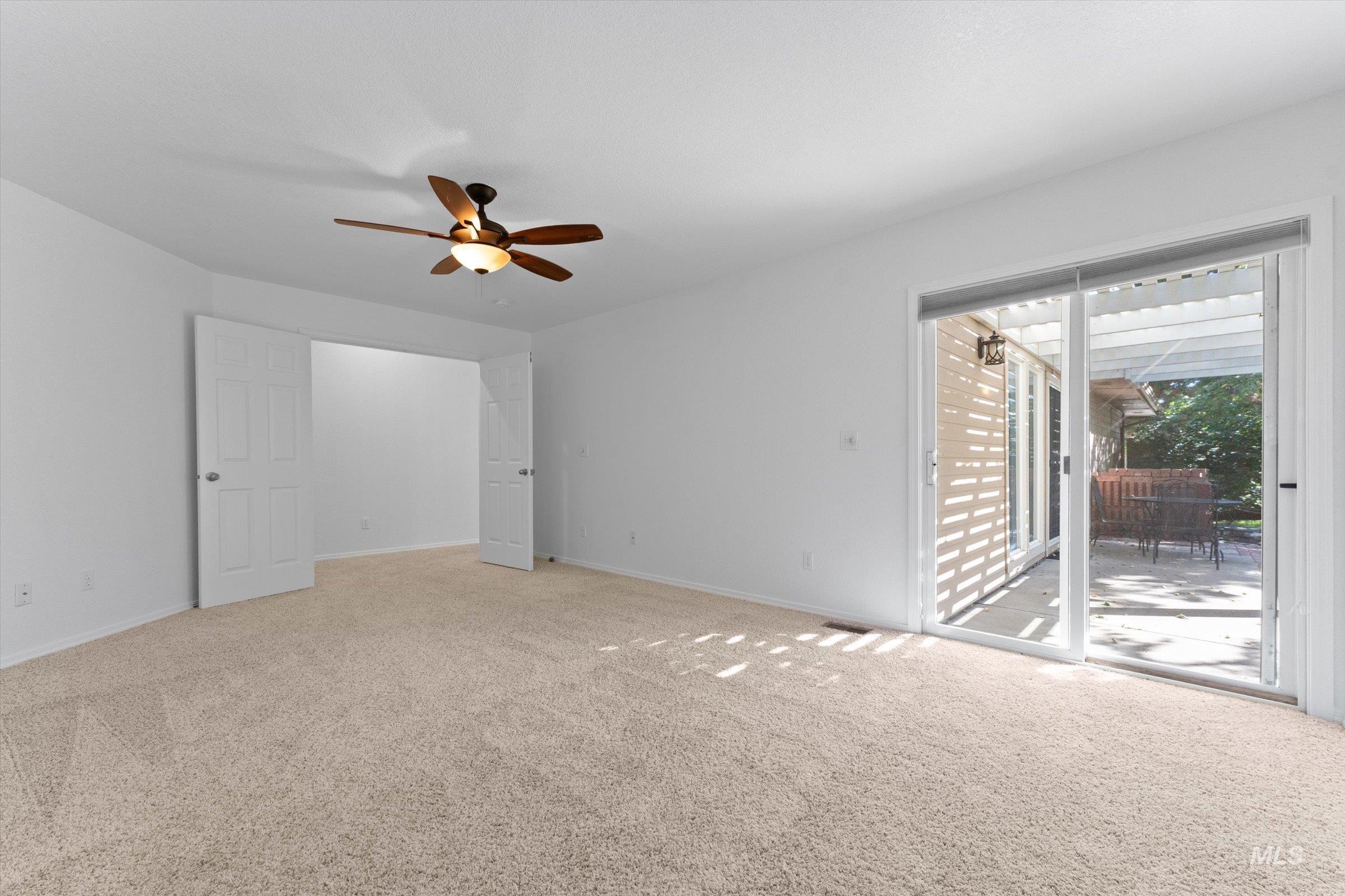 Unfurnished living room with carpet and ceiling fan