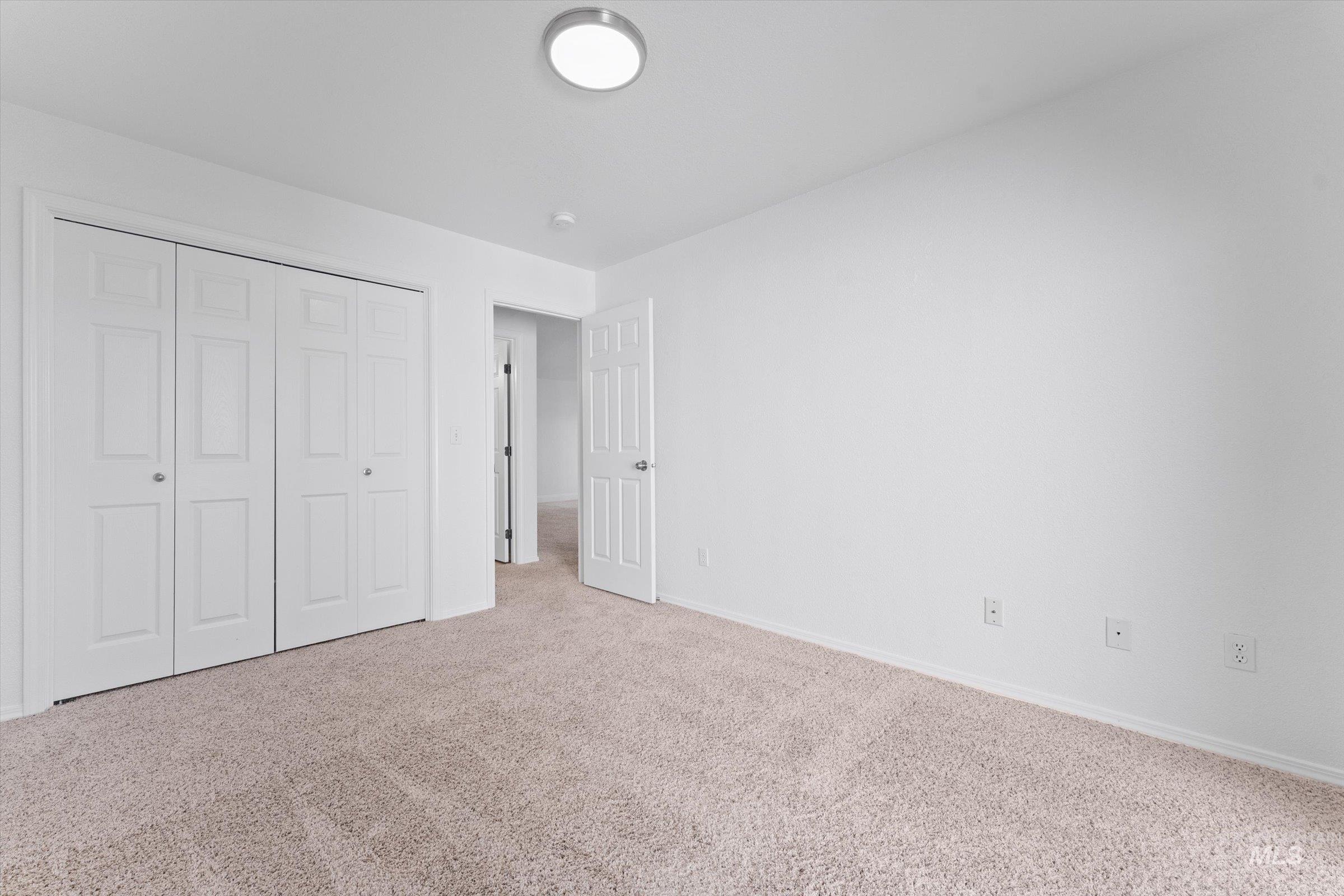 Unfurnished bedroom with carpet flooring and a closet