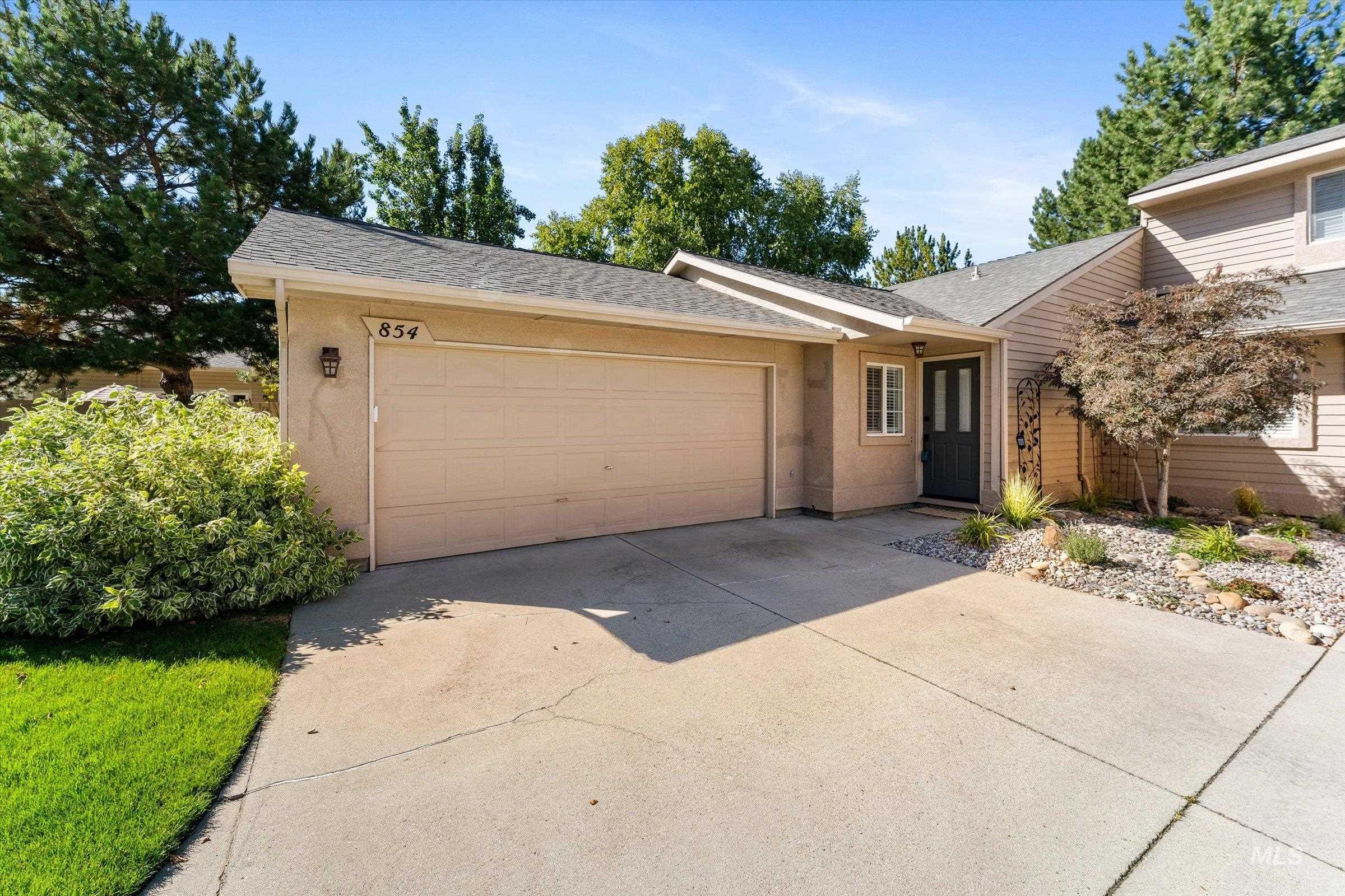 View of front of home featuring concrete driveway, a garage, and a shingled roof