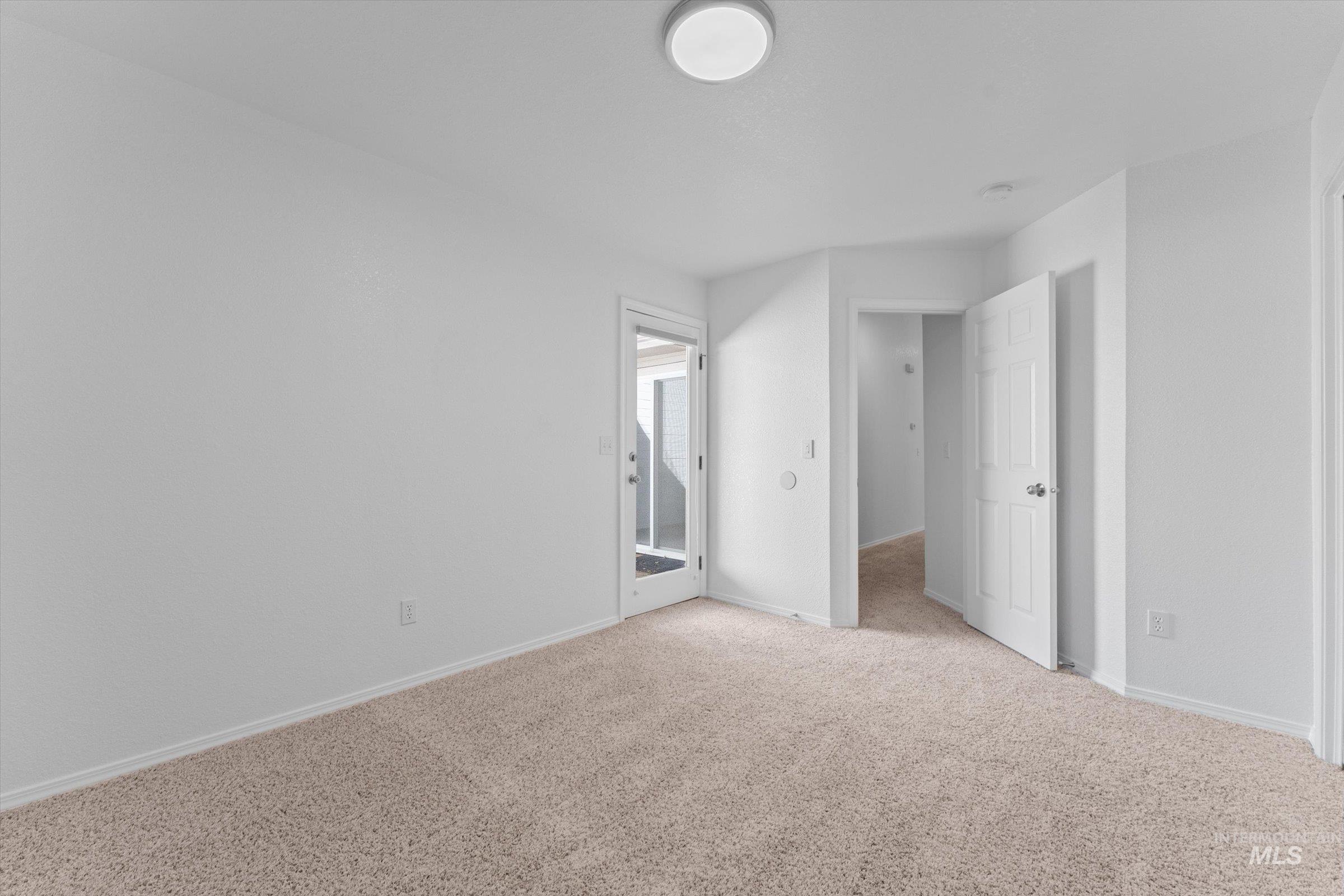 Unfurnished bedroom featuring light carpet and baseboards