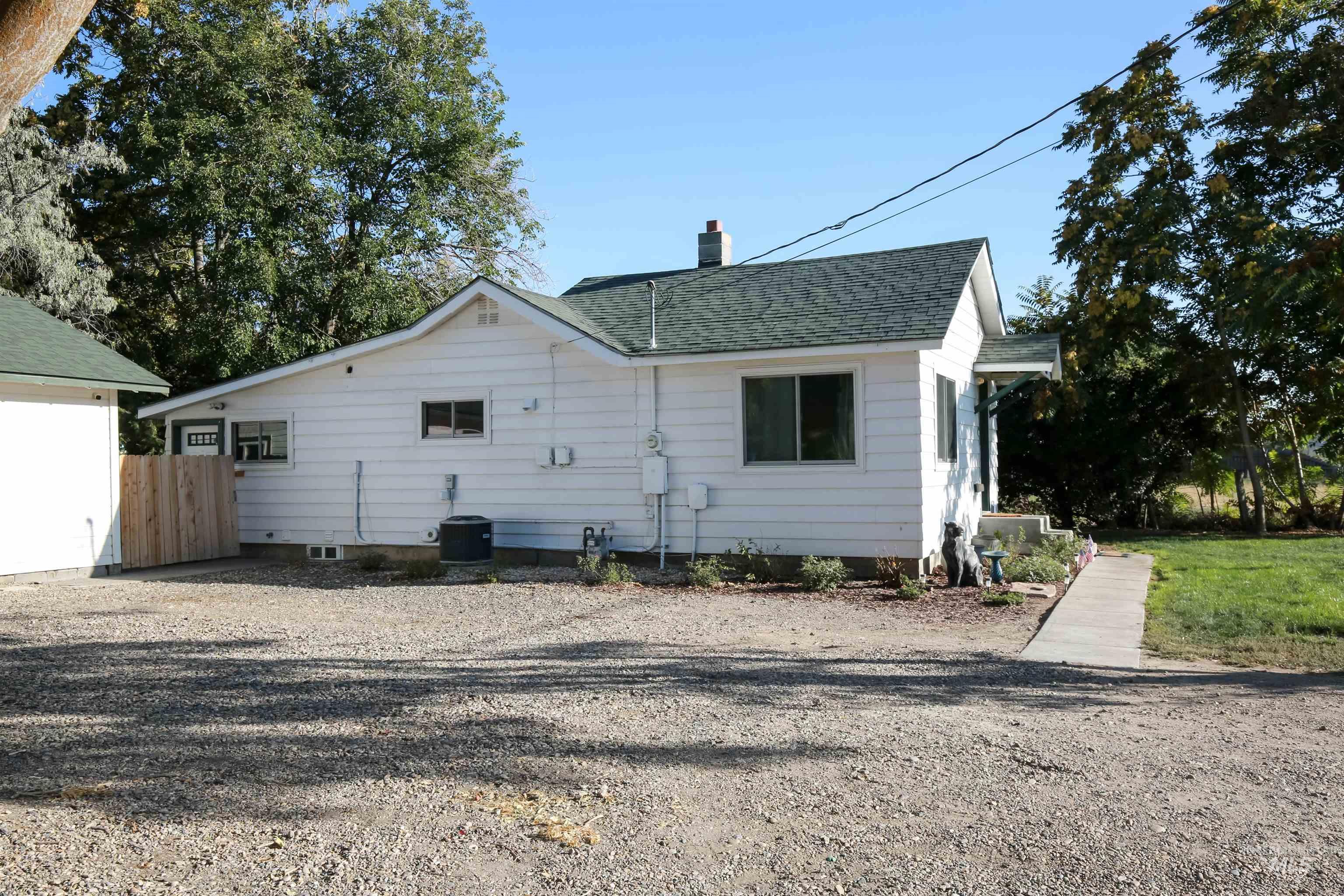 Back of house with a shingled roof and a chimney