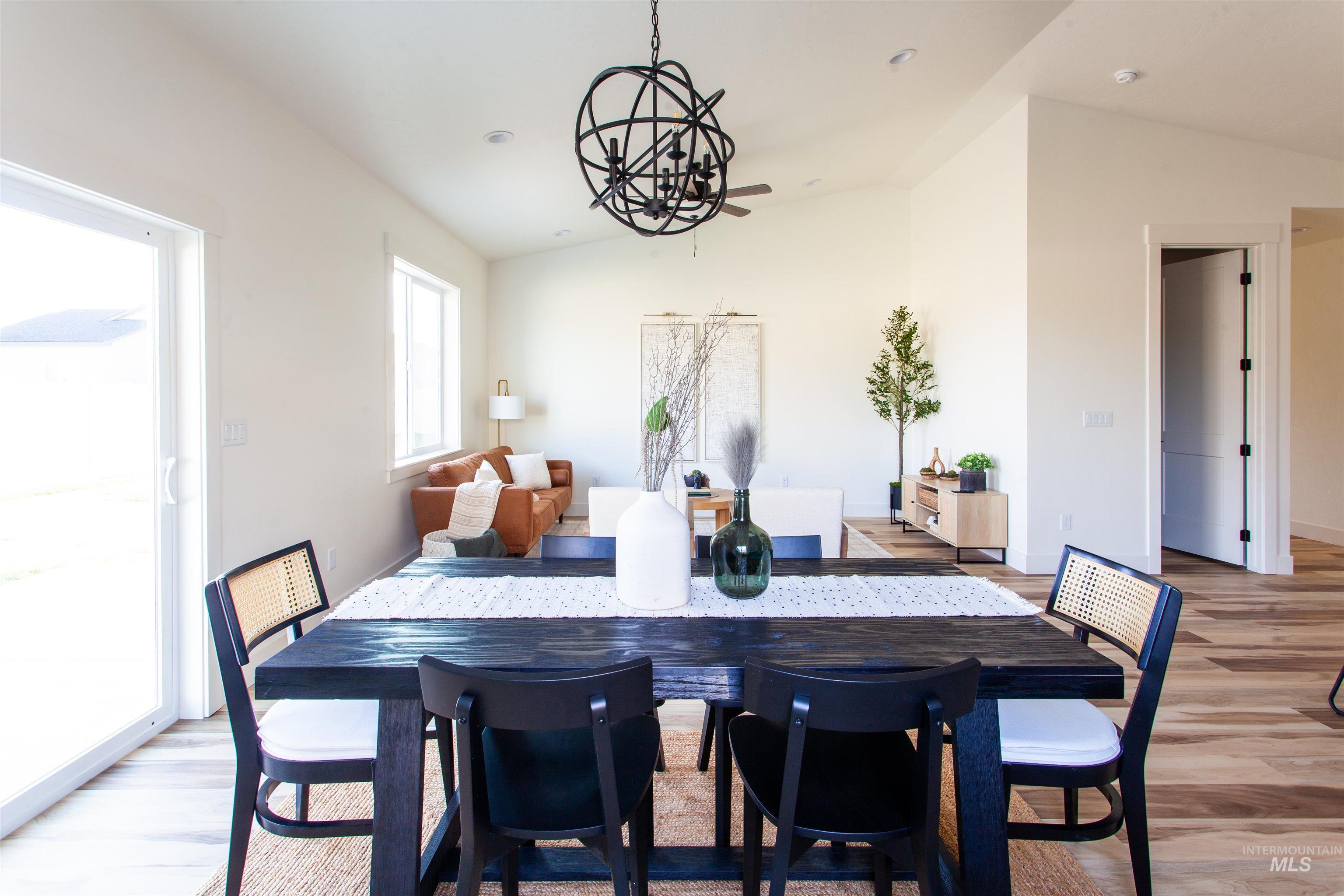 Dining space with vaulted ceiling, light wood-style flooring, a chandelier, and recessed lighting