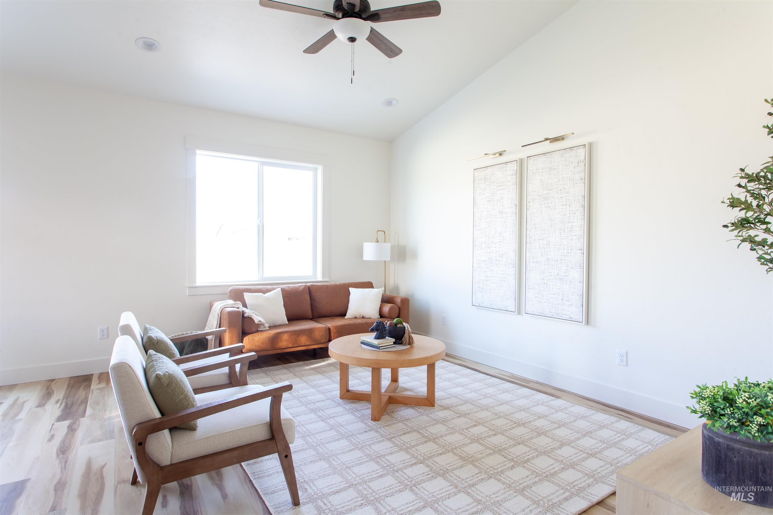 Living area with wood finished floors, lofted ceiling, and a ceiling fan