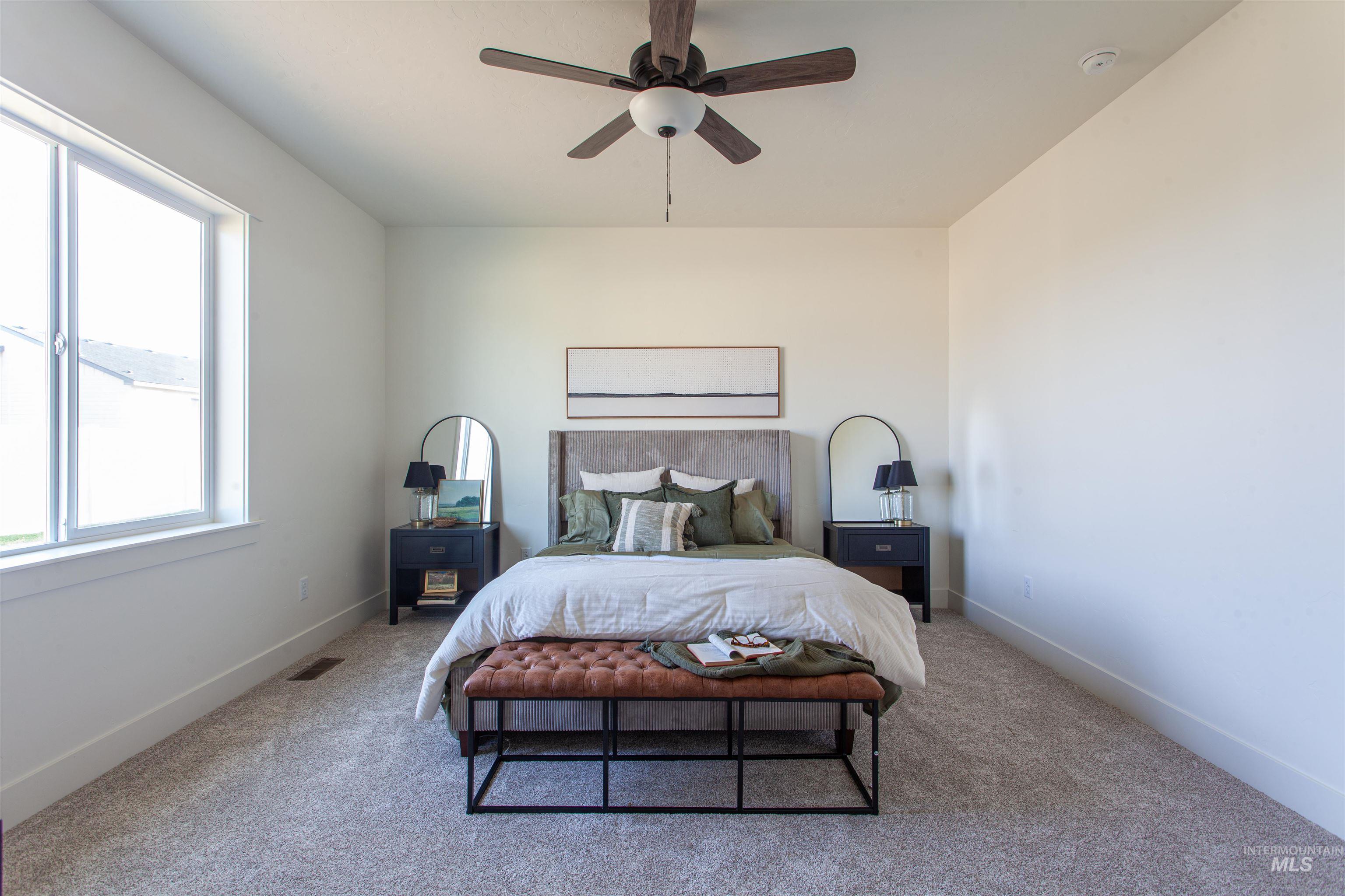 Carpeted bedroom featuring baseboards and ceiling fan