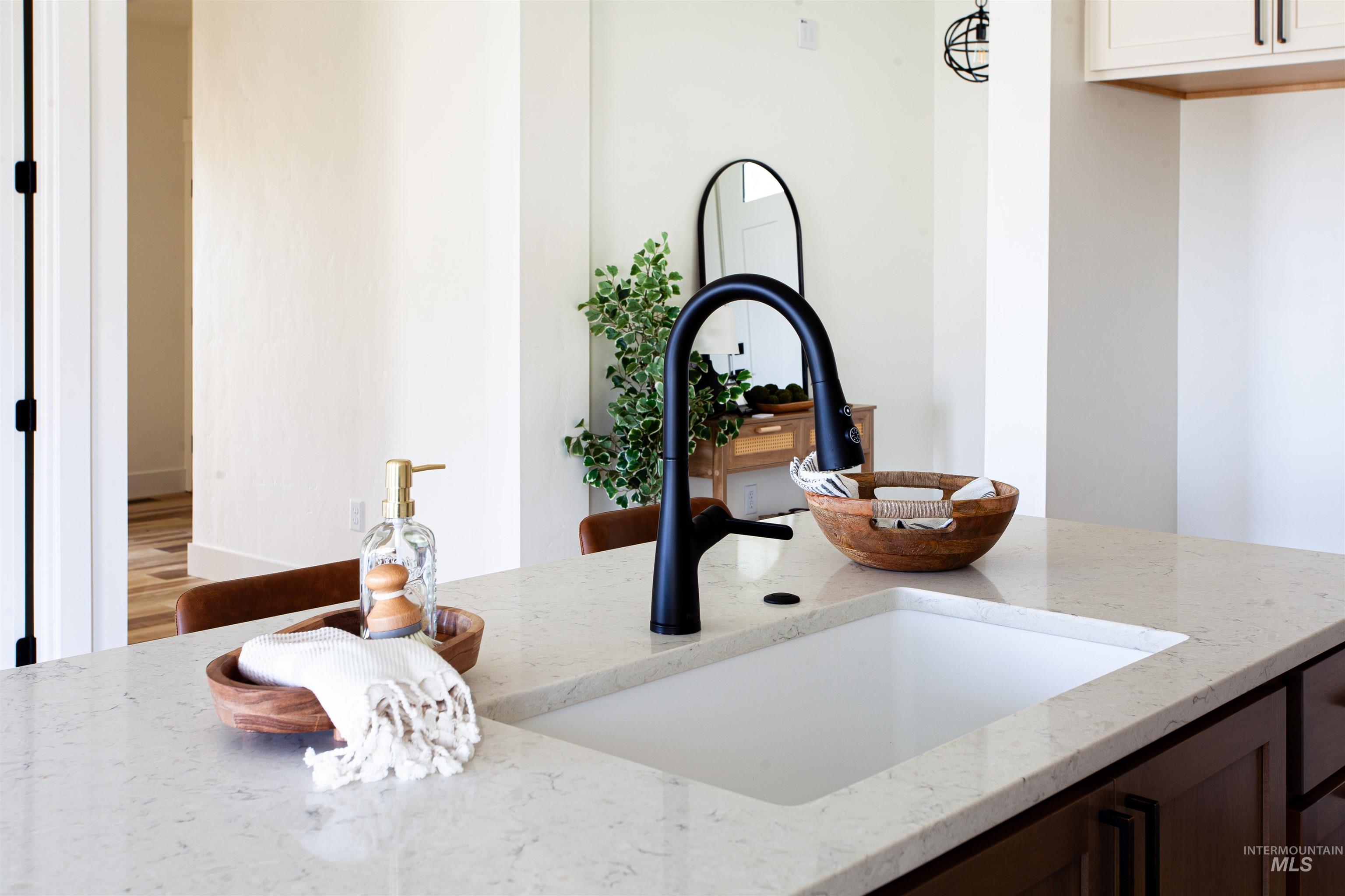 Kitchen view of light stone counters and dark brown cabinetry