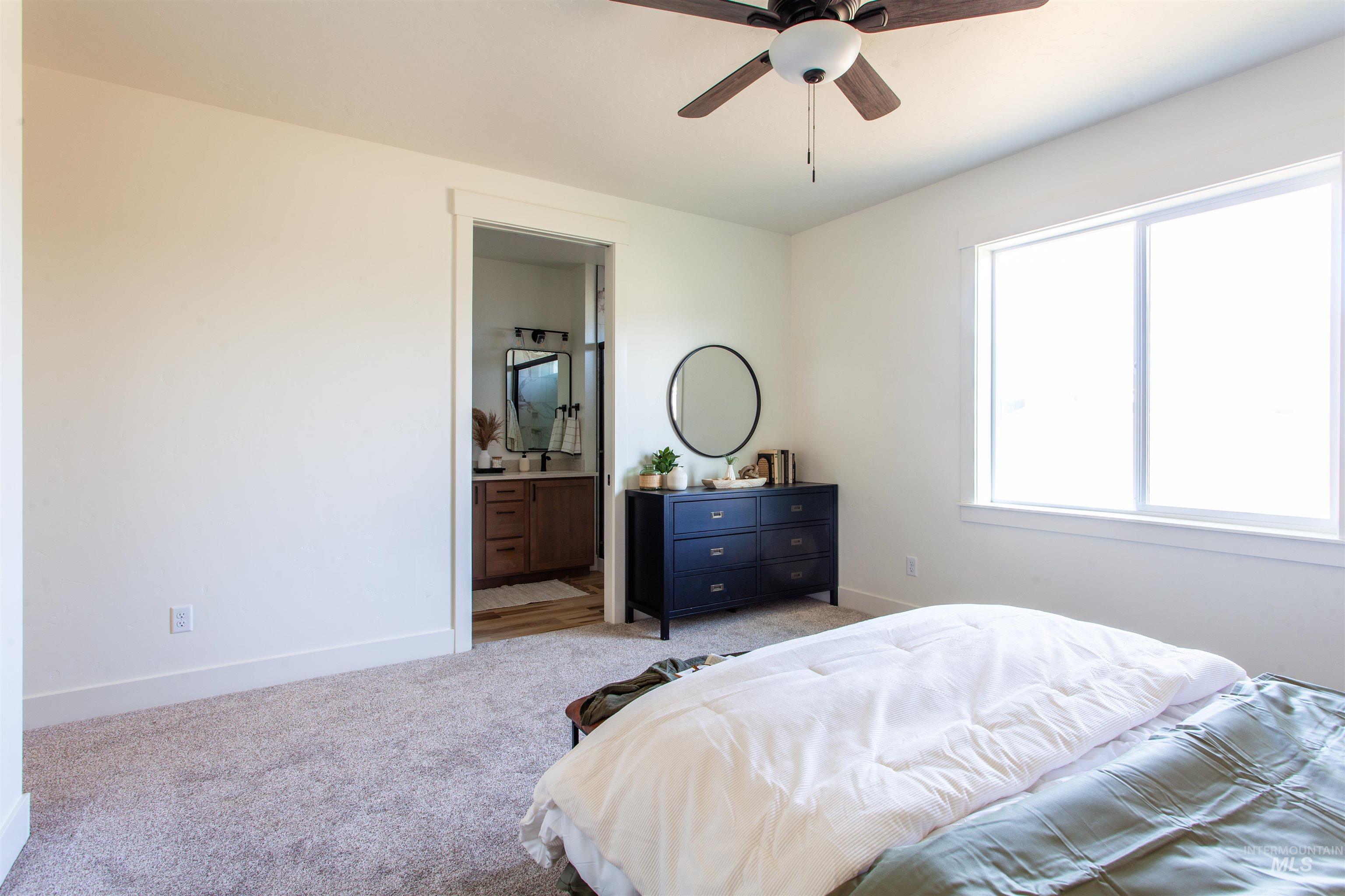 Bedroom with carpet flooring, ceiling fan, and connected bathroom