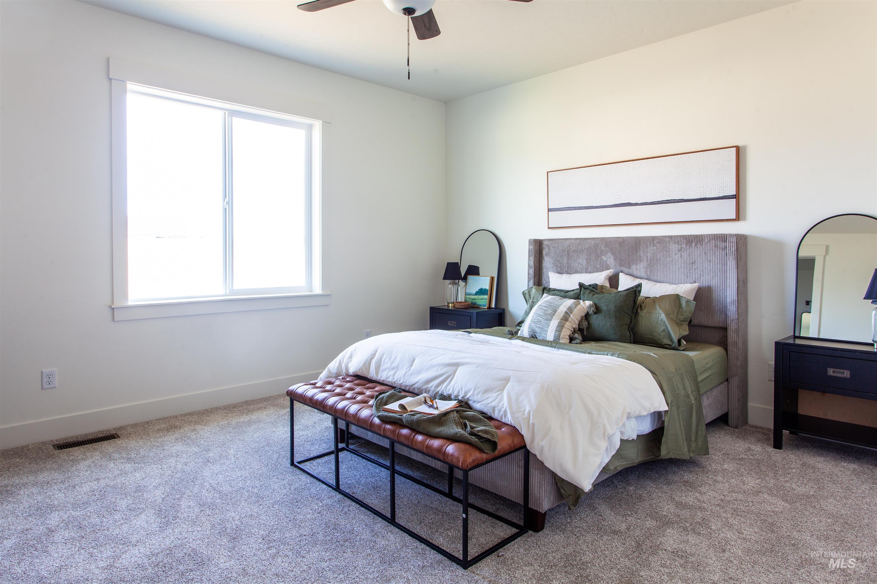 Carpeted bedroom featuring ceiling fan and baseboards