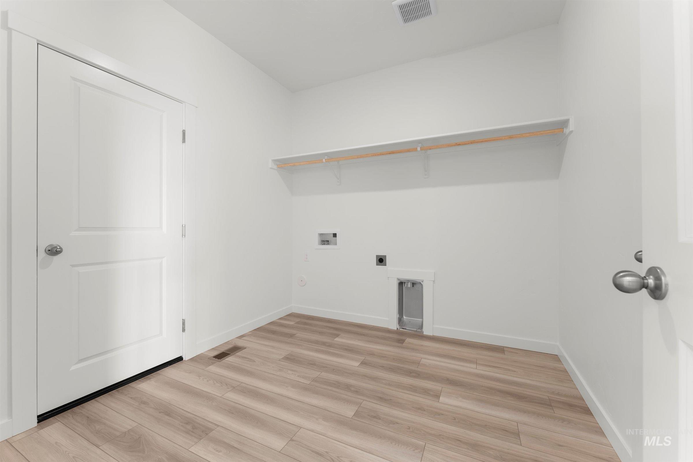 Washroom with hookup for an electric dryer, light wood-style floors, and washer hookup