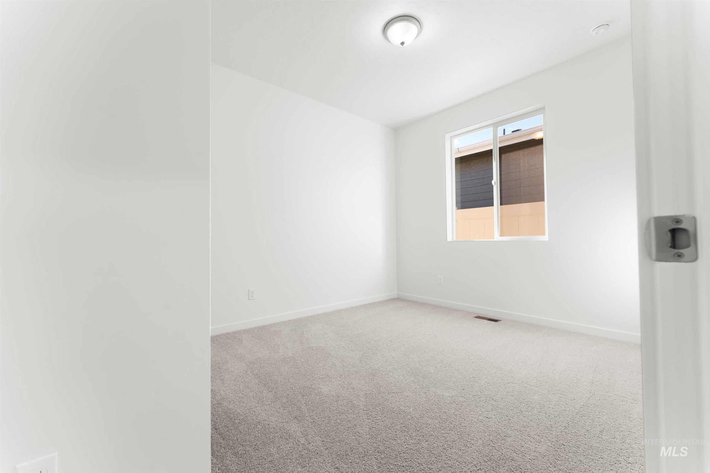 Unfurnished room featuring light carpet and baseboards