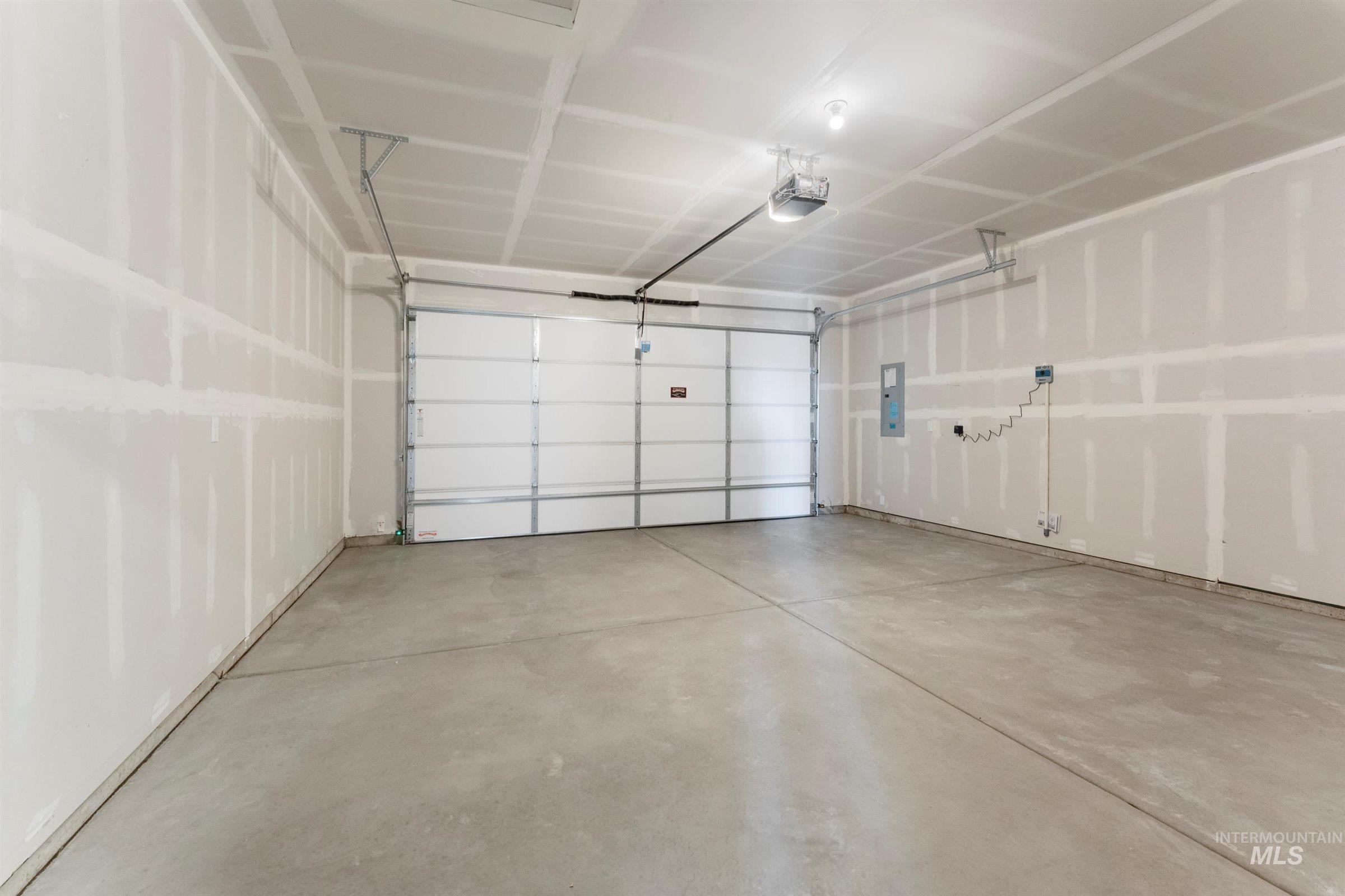 Garage featuring electric panel and a garage door opener