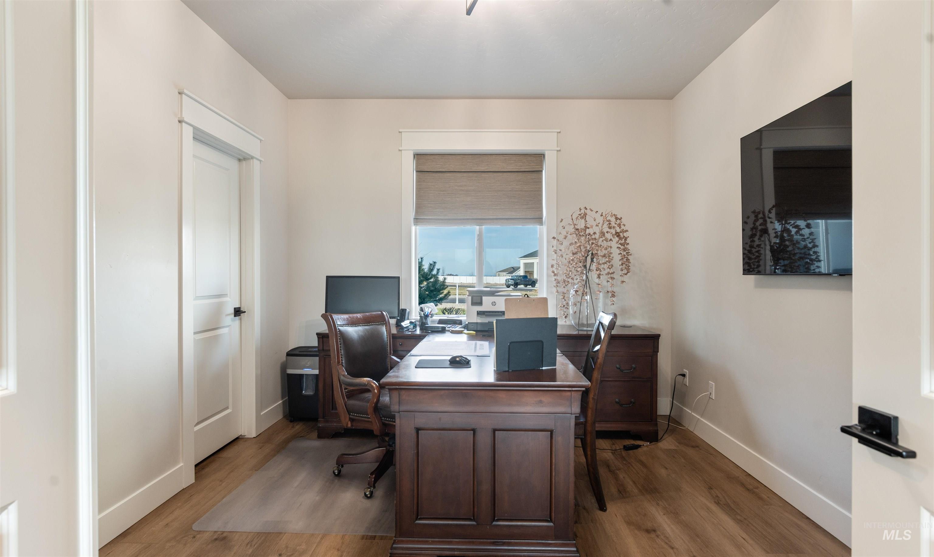 Office with light wood-type flooring and baseboards