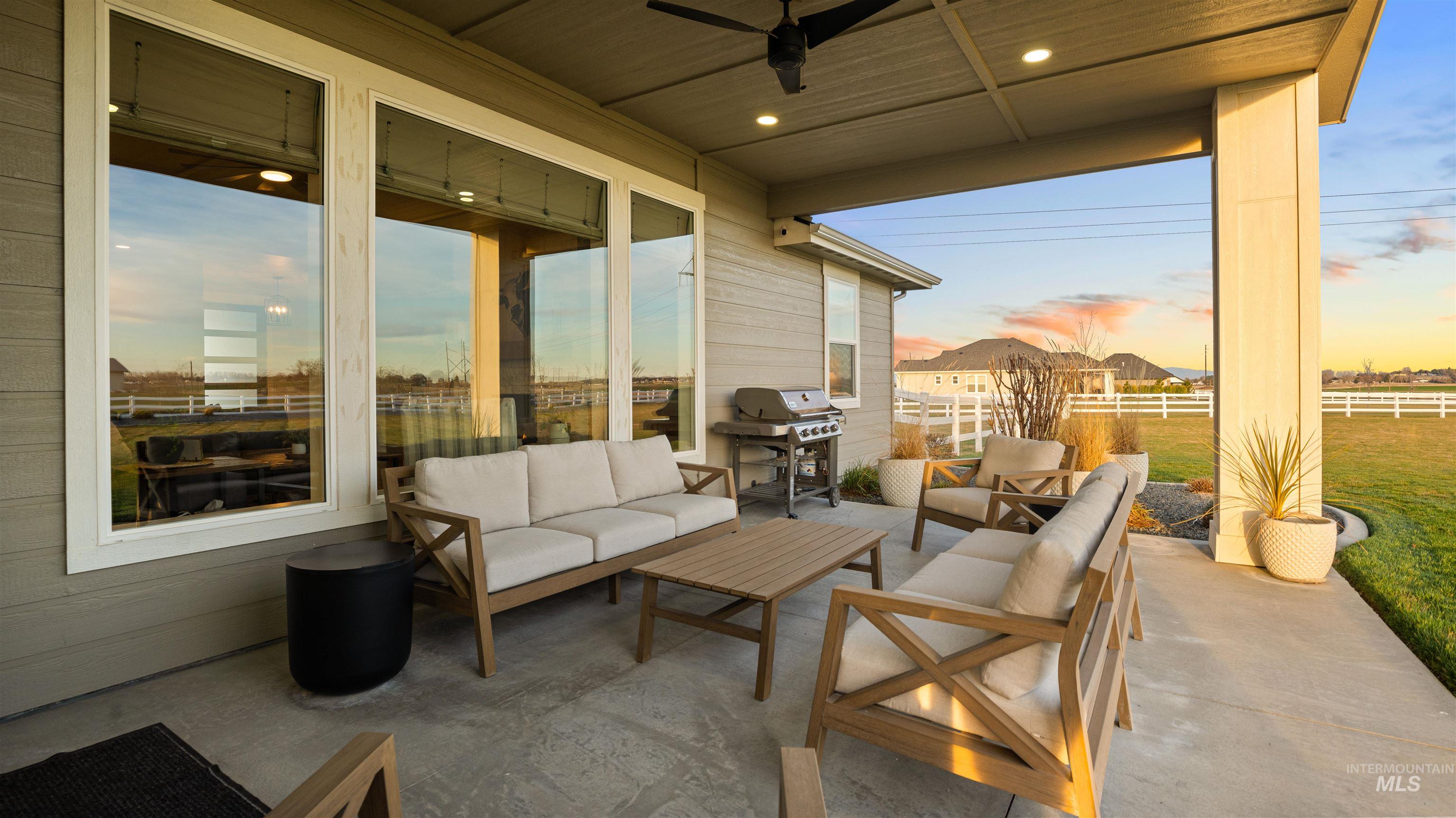 Patio terrace at dusk featuring an outdoor hangout area, a grill, ceiling fan, and a patio area
