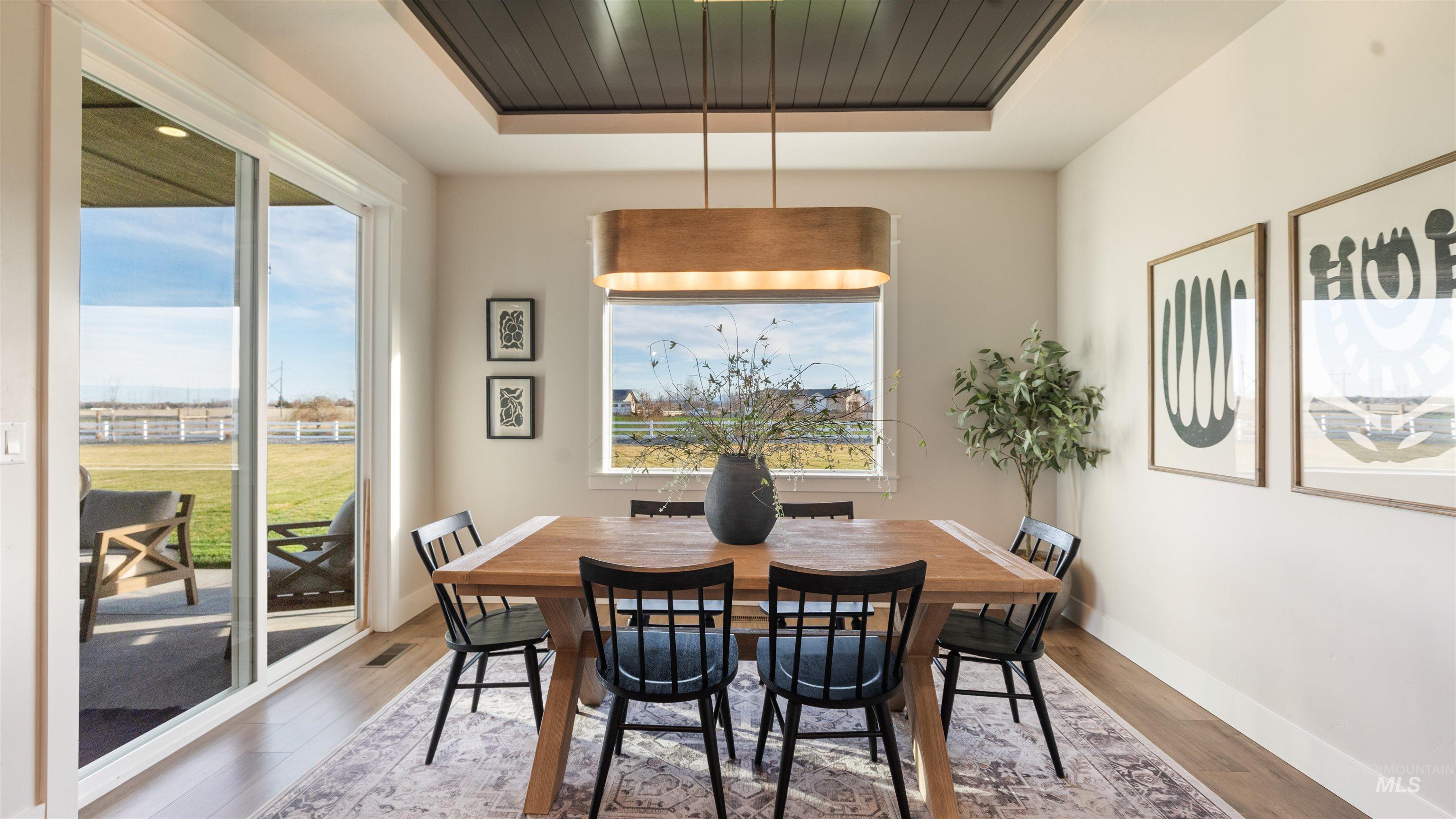 Dining room featuring a raised ceiling and wood finished floors