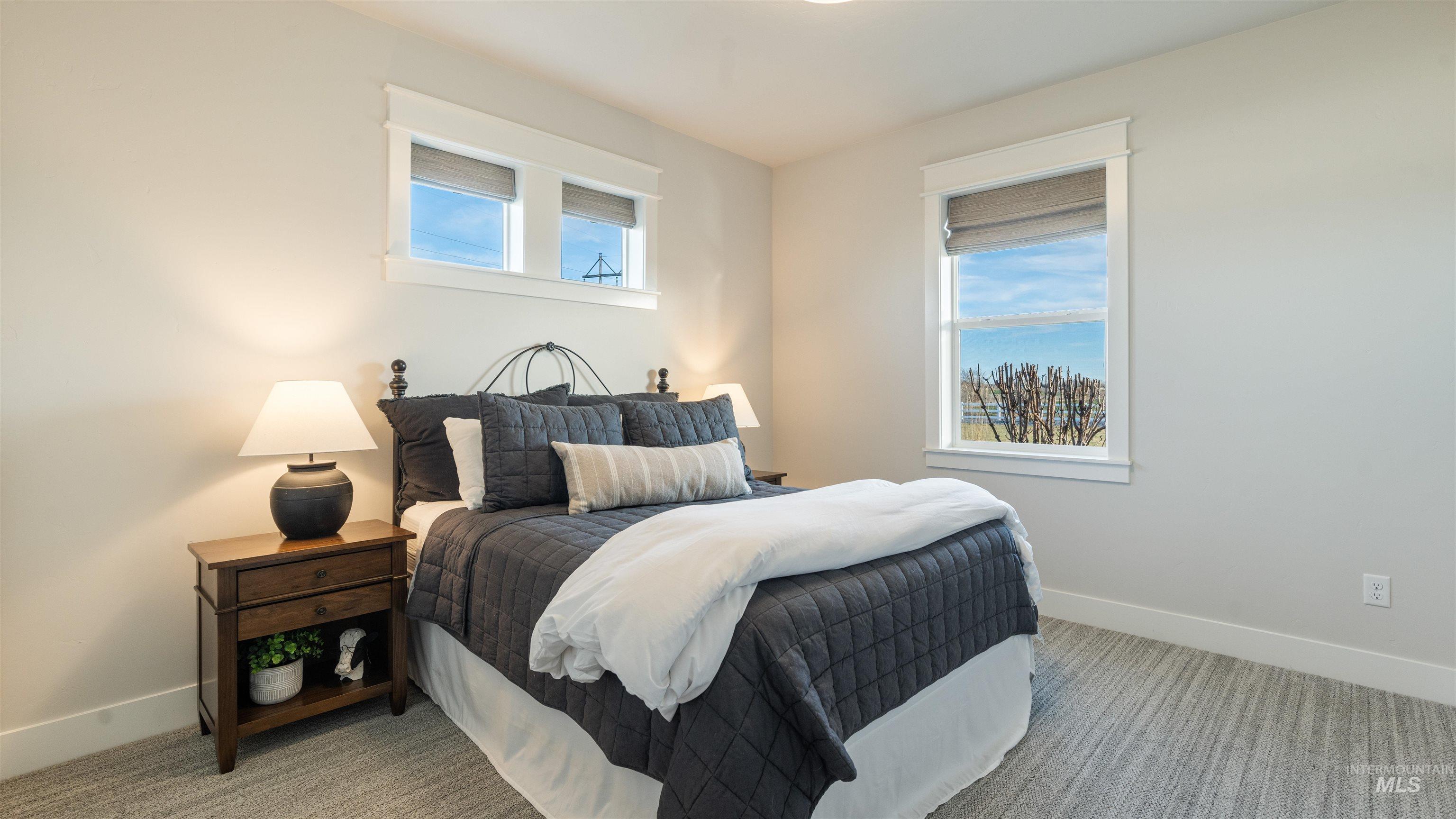 Bedroom featuring multiple windows and light carpet