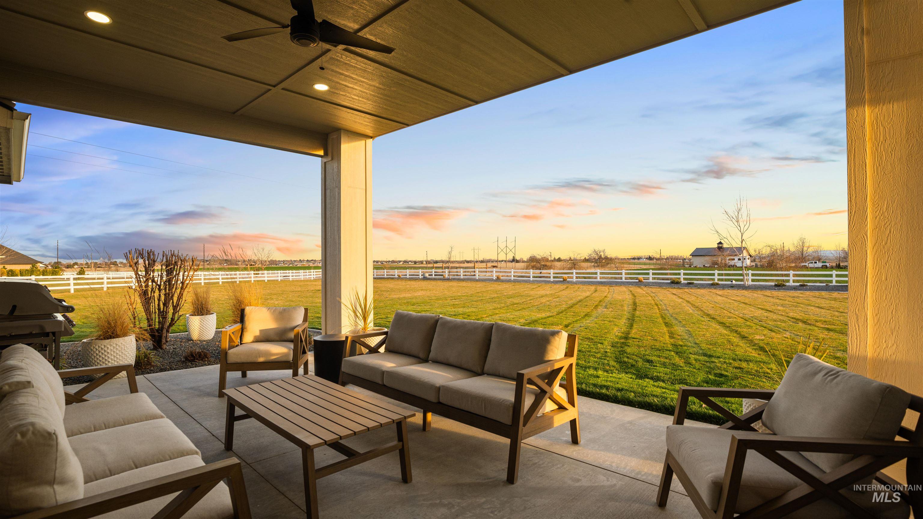 Fenced backyard with outdoor furniture, a patio, a ceiling fan, and grilling area