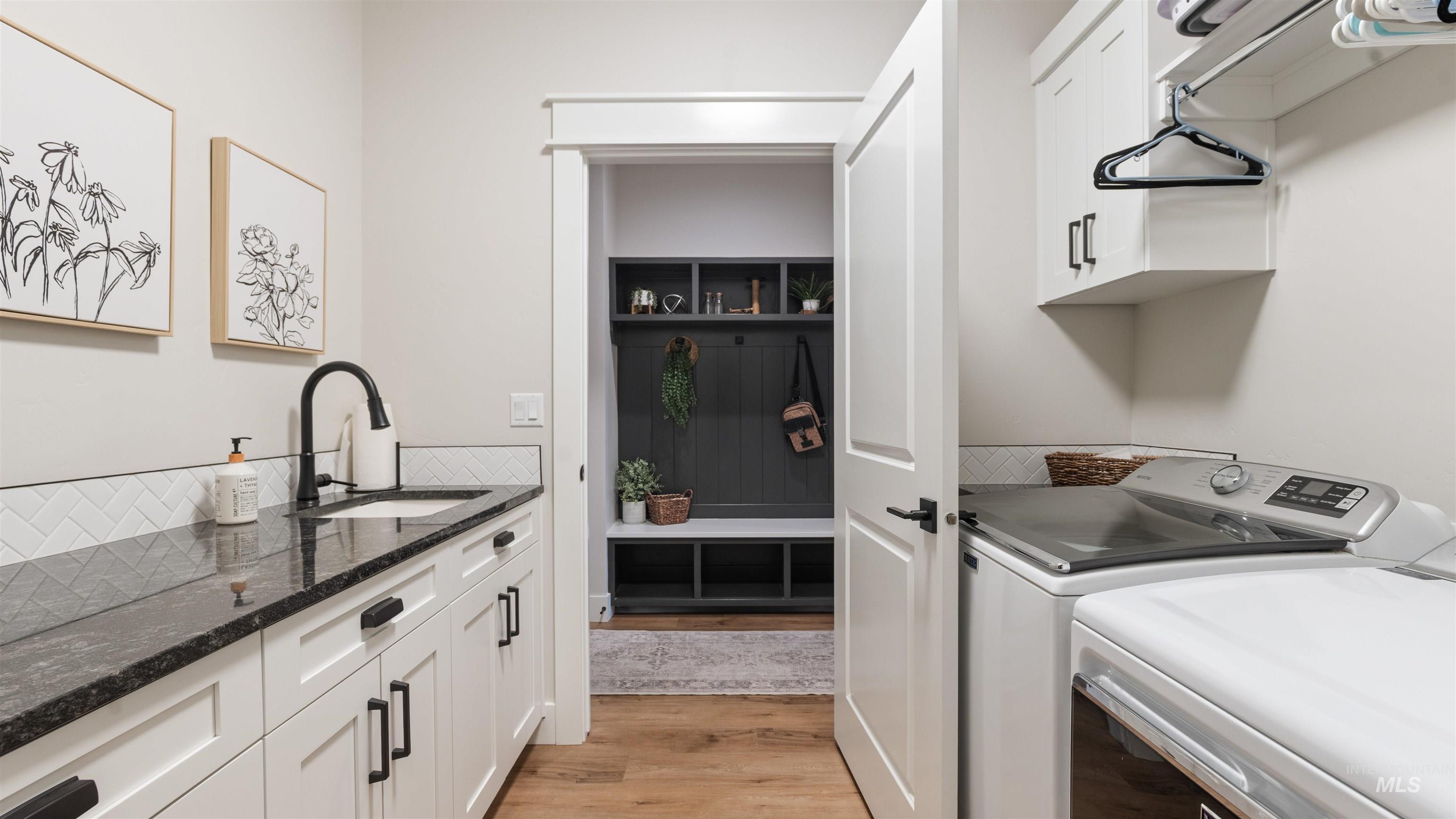 Laundry room with cabinet space, light wood-style flooring, and separate washer and dryer