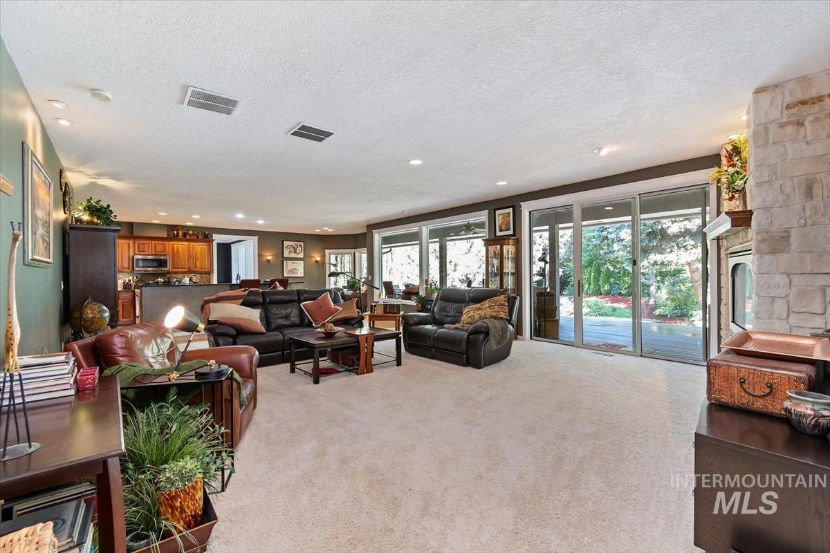 Living room with carpet flooring, a textured ceiling, and recessed lighting