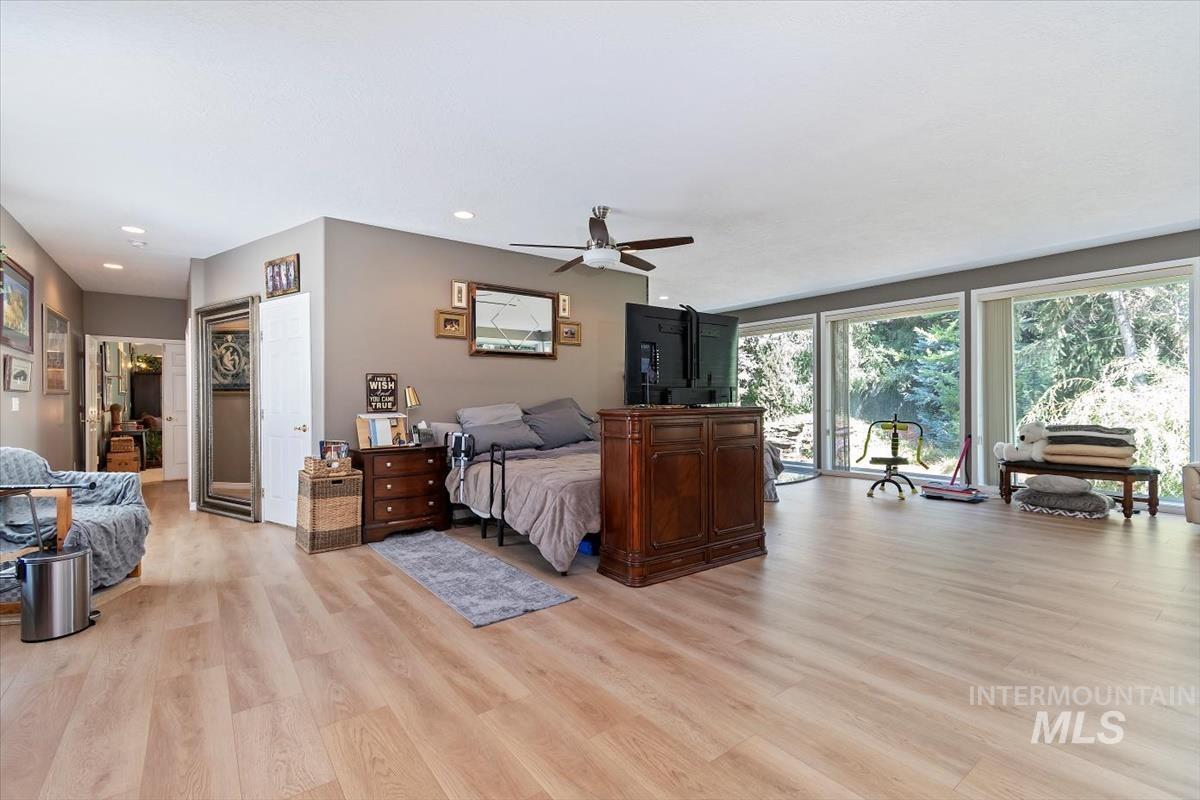 Bedroom featuring light wood-style flooring, access to exterior, ceiling fan, and recessed lighting