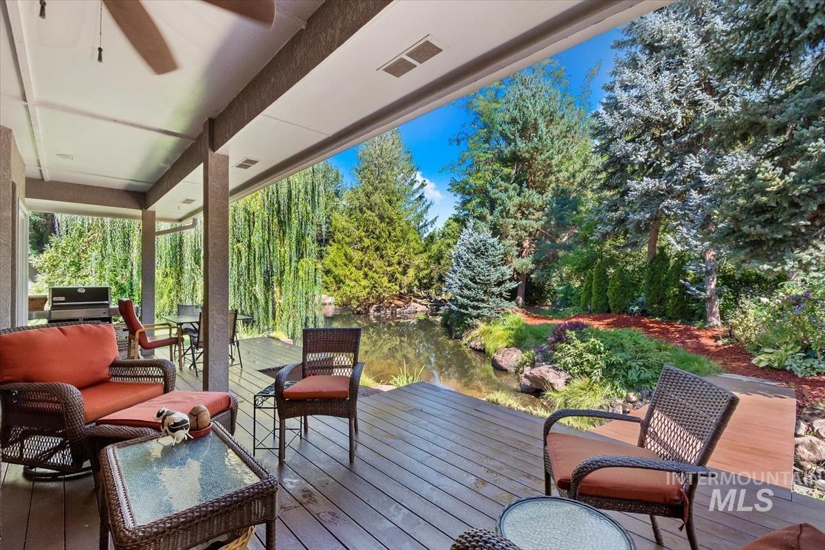 Wooden terrace with view of scattered trees, ceiling fan, and a grill