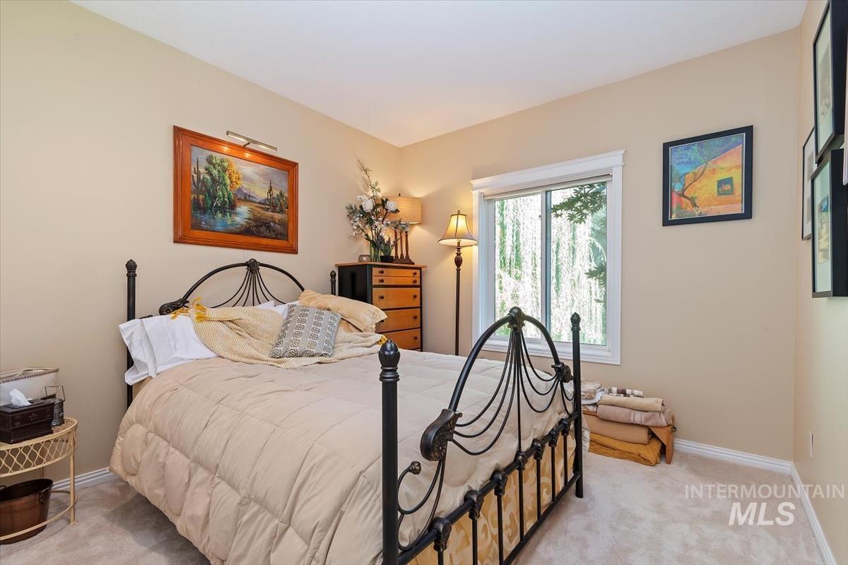 Bedroom with light colored carpet and baseboards