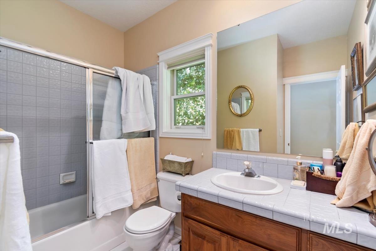 Full bathroom featuring enclosed tub / shower combo and vanity
