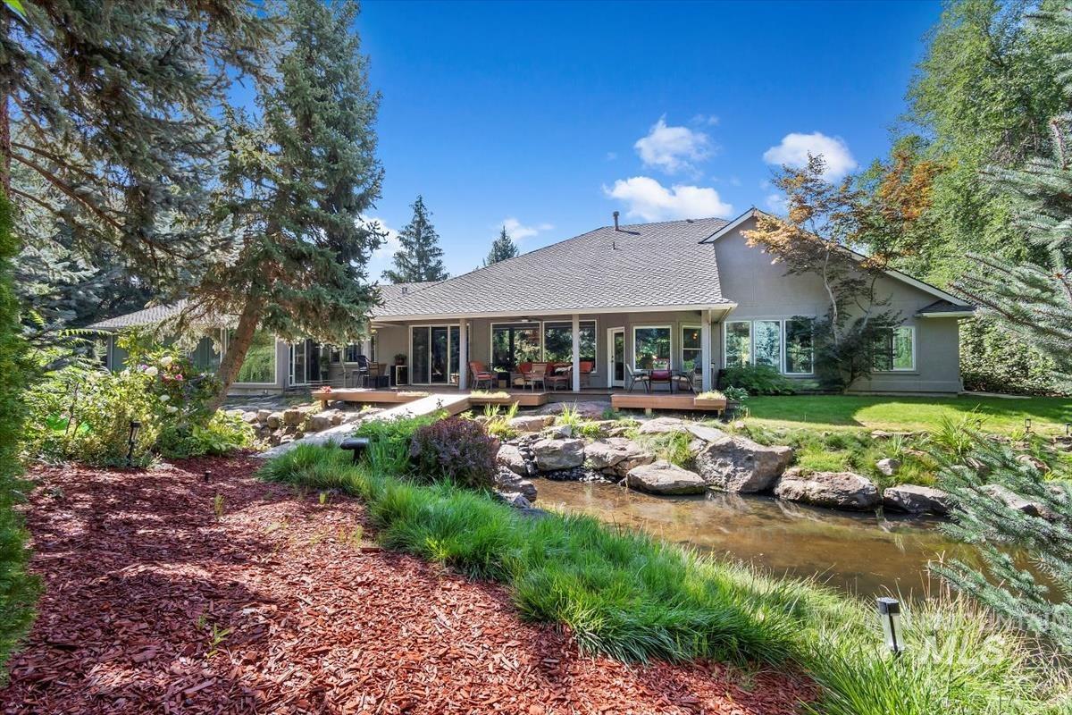 Back of house featuring stucco siding, a wooden deck, and a yard