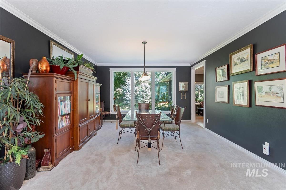 Dining room featuring crown molding and light colored carpet