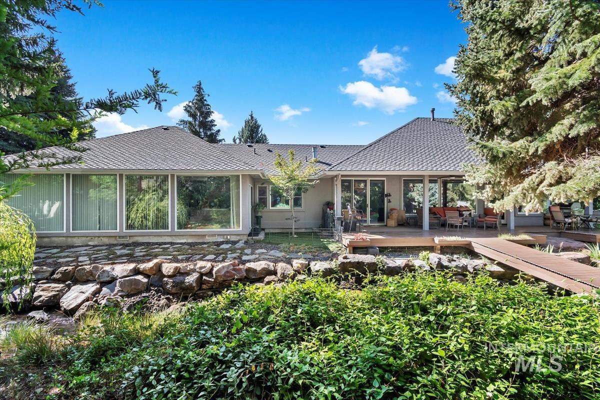 Back of house with a deck and outdoor dining area