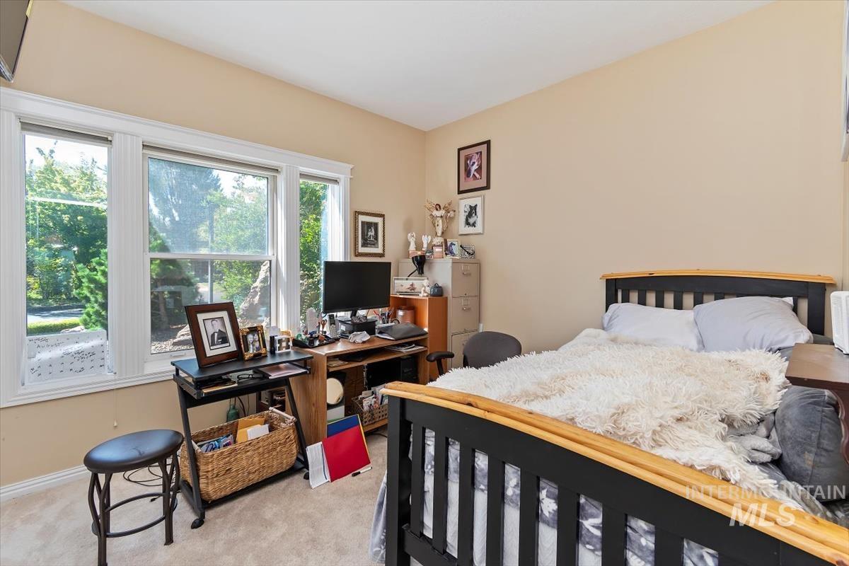 Carpeted bedroom featuring an office area