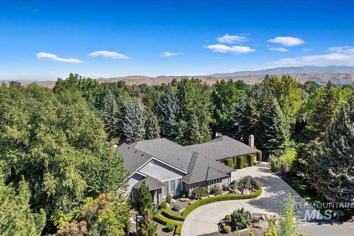 Aerial view of property and surrounding area featuring a mountain backdrop