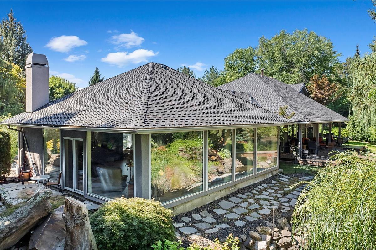 Rear view of property with a chimney, roof with shingles, and a patio