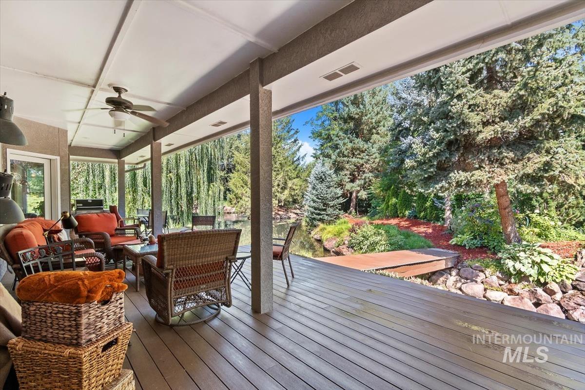Deck with outdoor lounge area, ceiling fan, and view of scattered trees