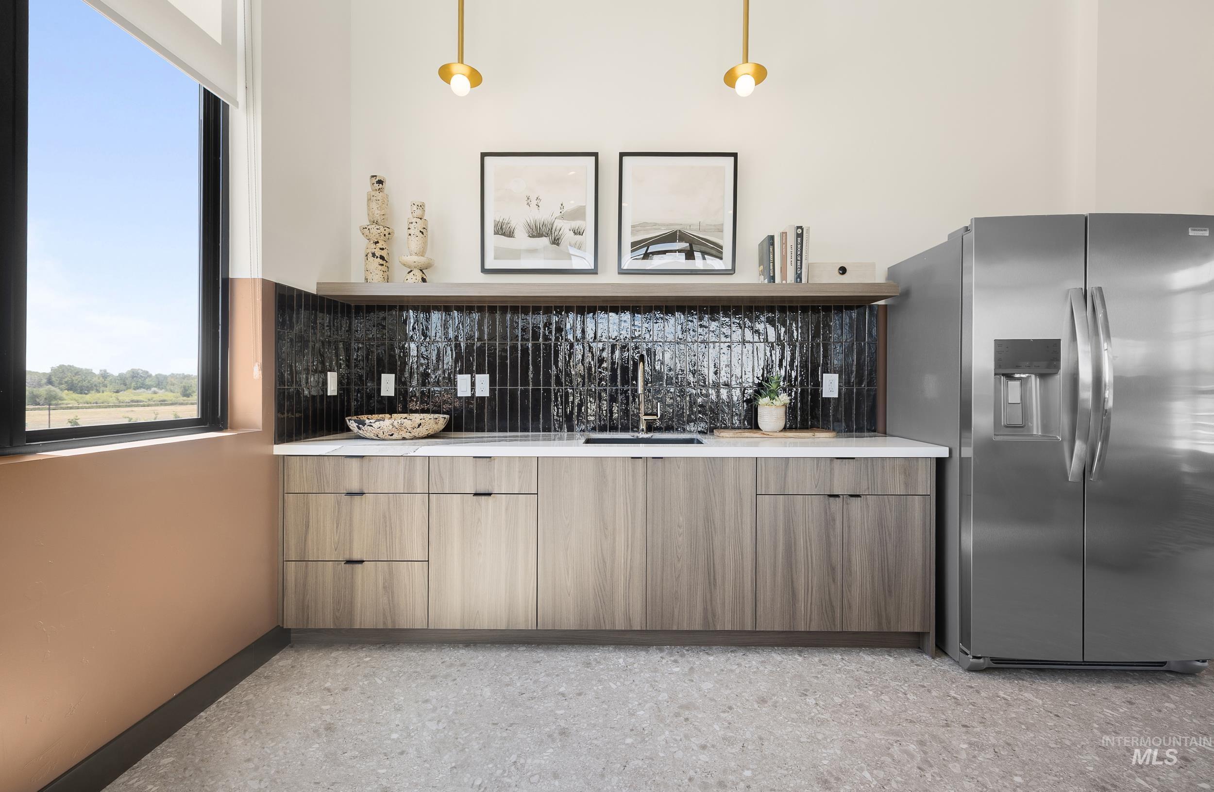 Bar area with stainless steel fridge, backsplash, and dark aggregate flooring