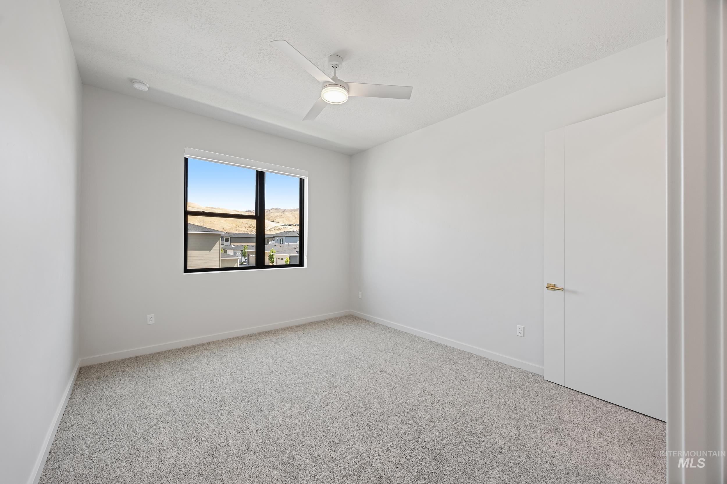 Unfurnished room featuring light colored carpet and ceiling fan