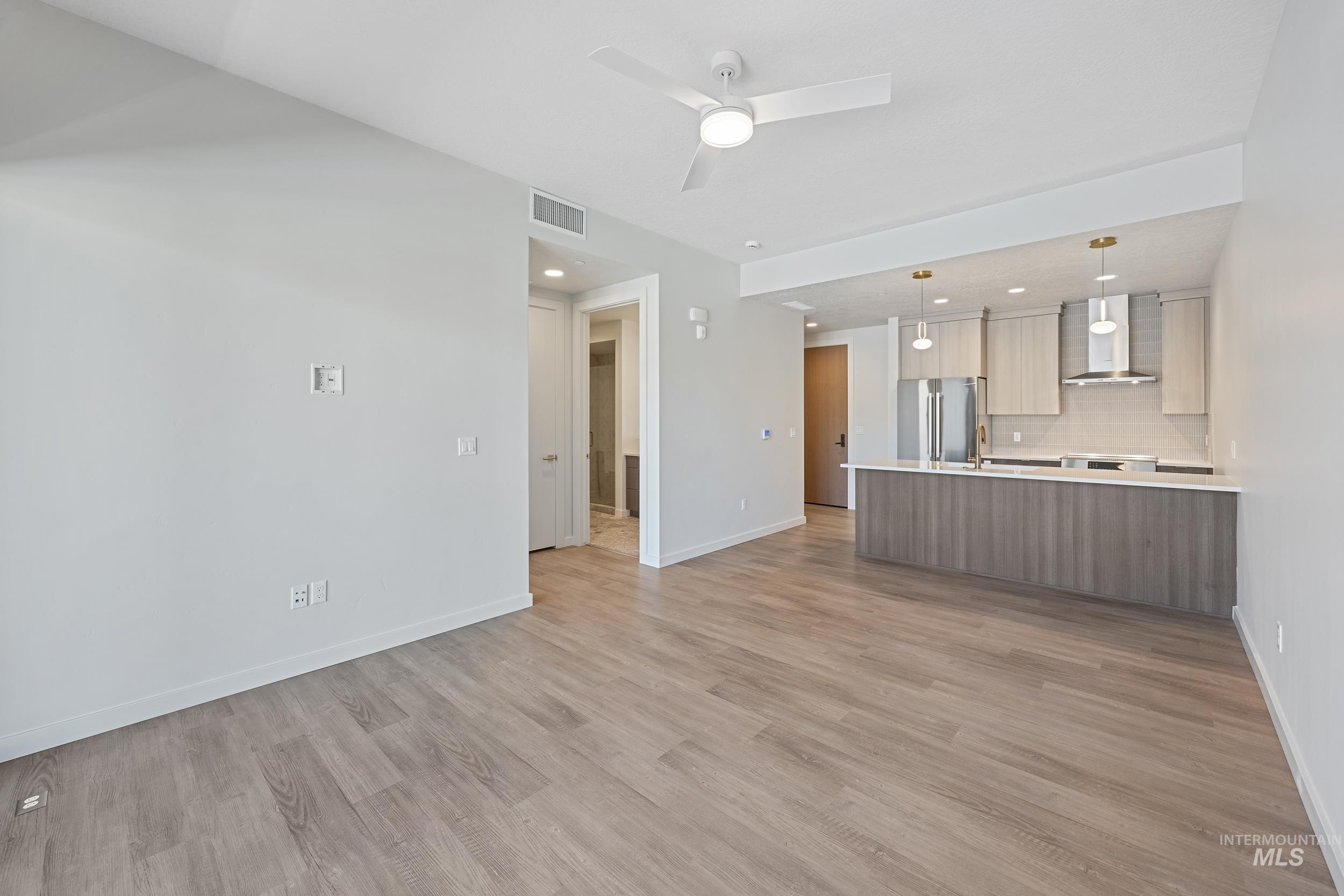 Unfurnished living room with light wood finished floors, ceiling fan, and recessed lighting