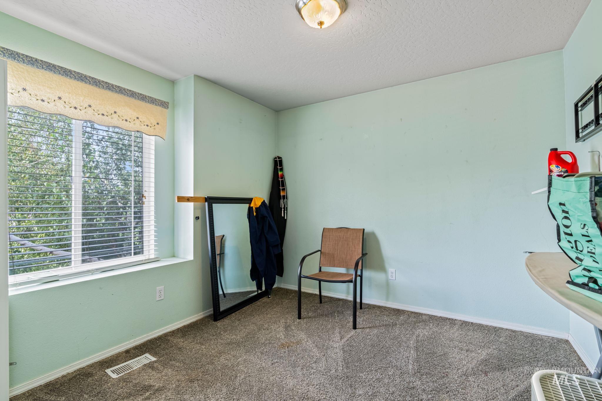 Living area with carpet and a textured ceiling