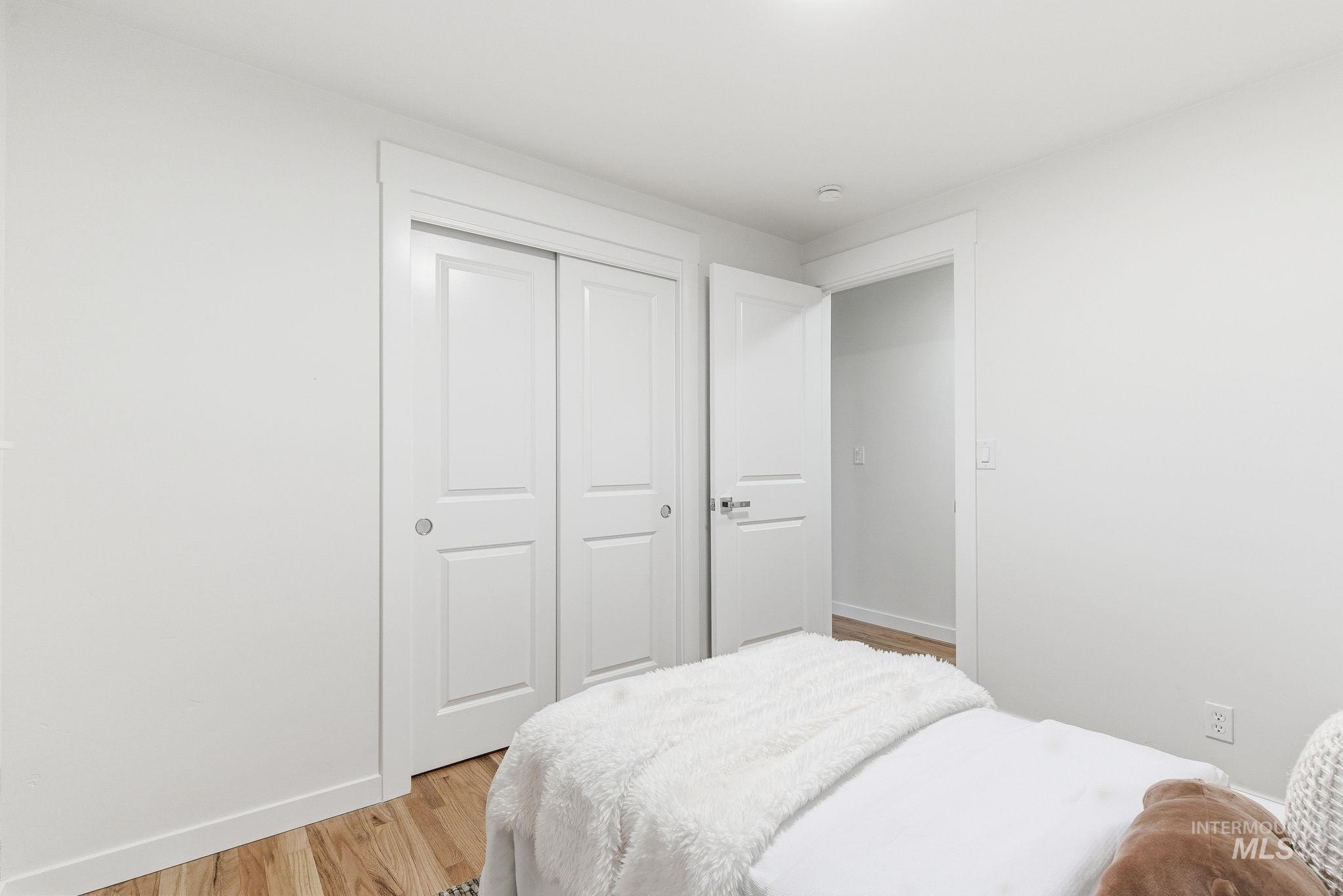 Bedroom with light wood finished floors and a closet